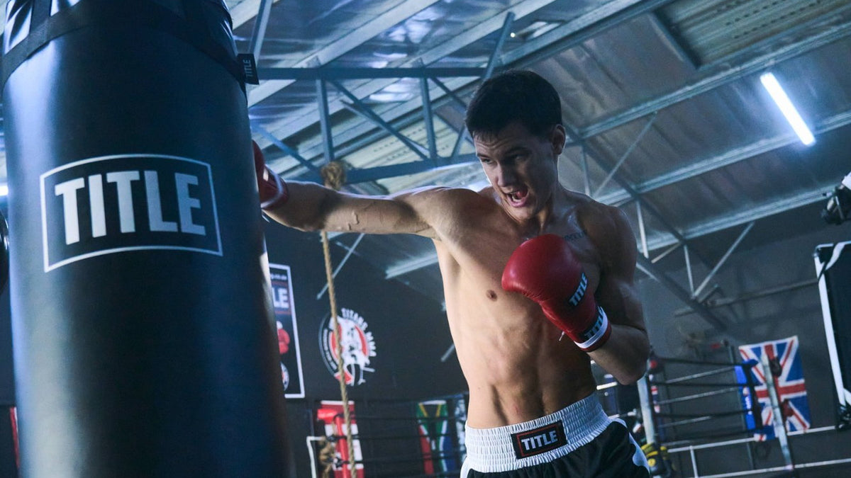 Boxer throwing a straight punch into a TITLE heavy bag during training in a South African gym