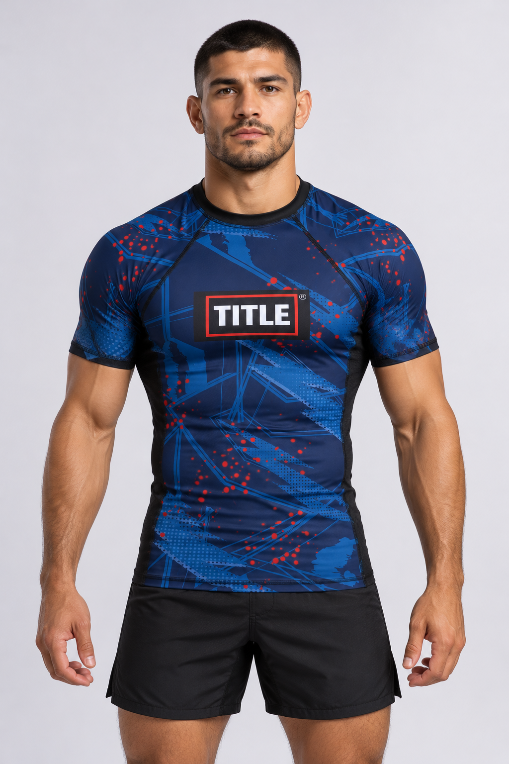 MMA athlete wearing the TITLE Chaos navy rash guard with blue and red print and red TITLE box logo, front view