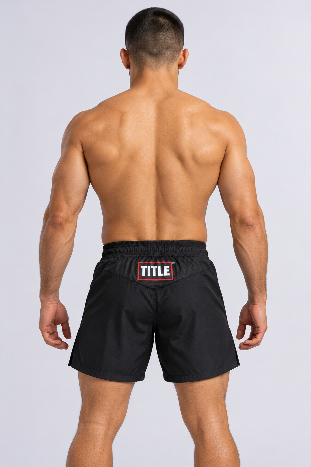 Back of TITLE Blackout black MMA shorts with V-shaped yoke panel, TITLE logo and elasticated waistband