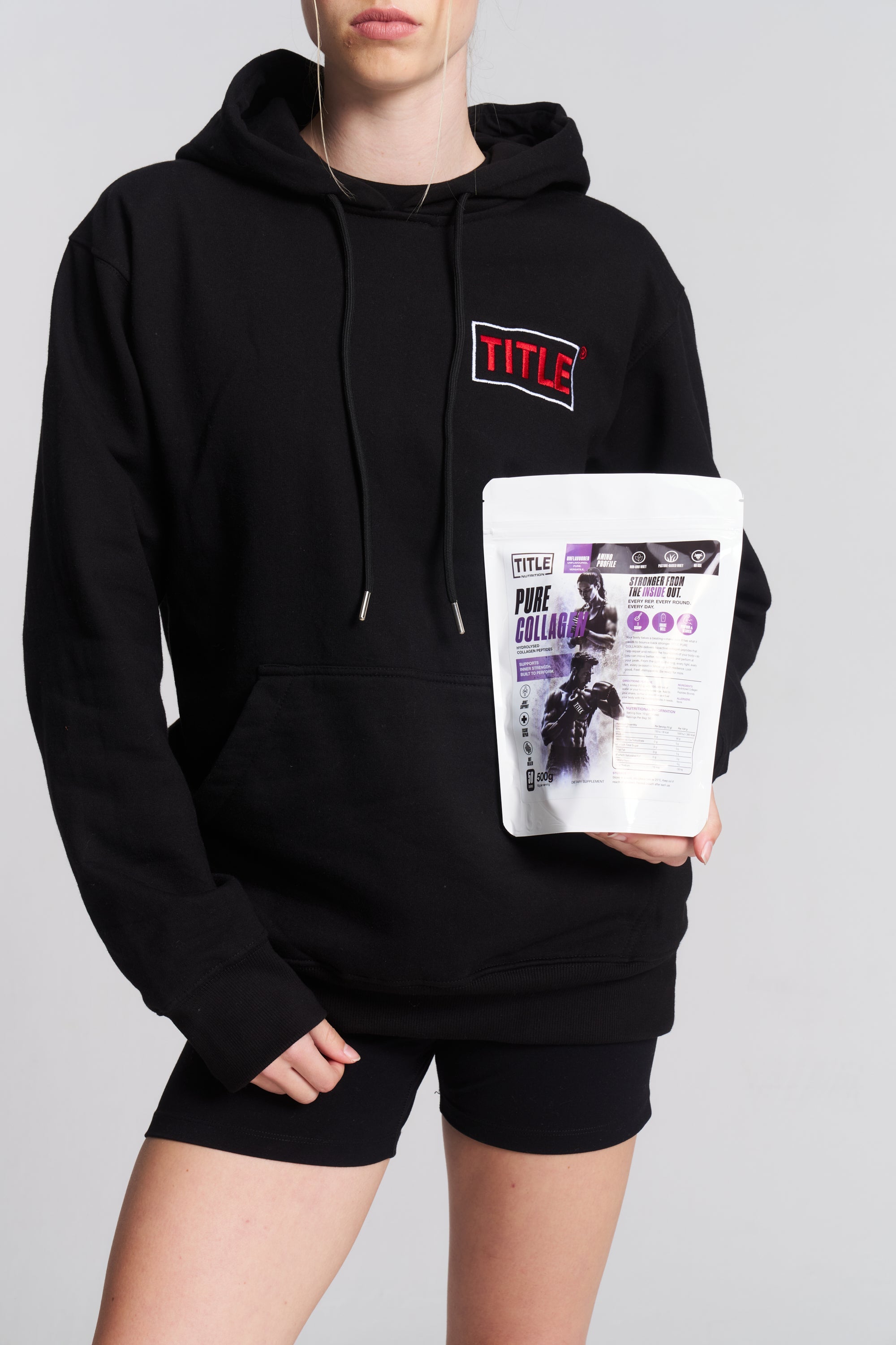 A person wearing a black hoodie holding a 500g bag of TITLE Boxing South Africa Pure Collagen hydrolysed peptides.