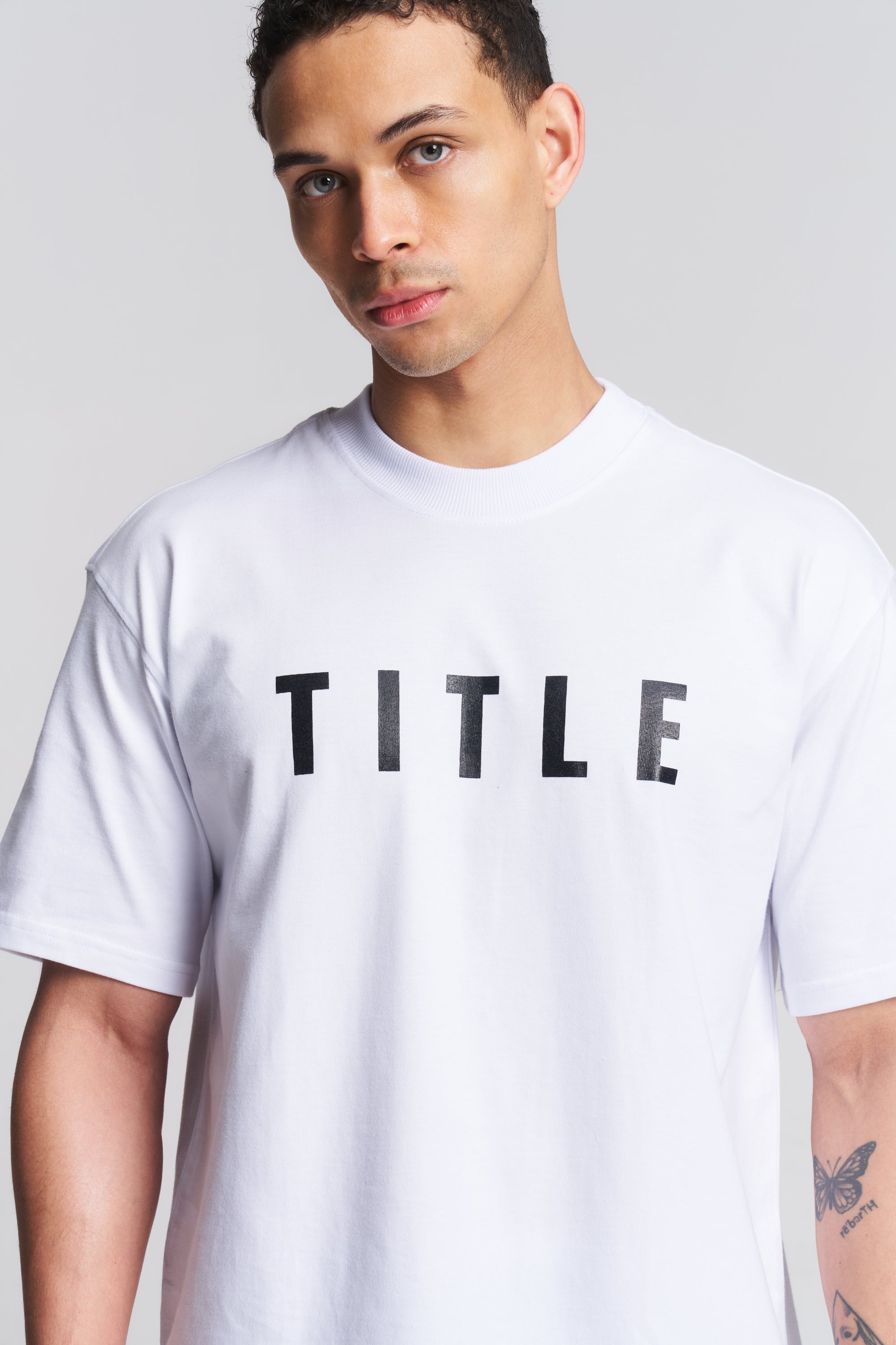 TITLE Boxing South Africa white oversized cotton t-shirt with black chest logo worn by a male model
