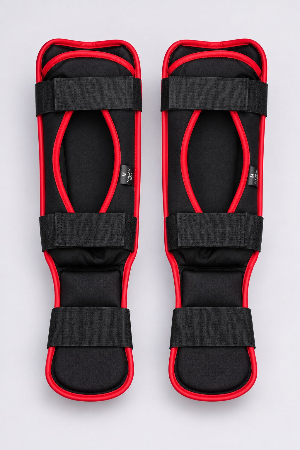 Back of TITLE Defender shin guards: black neoprene lining, red piping, two calf straps and an elastic foot band