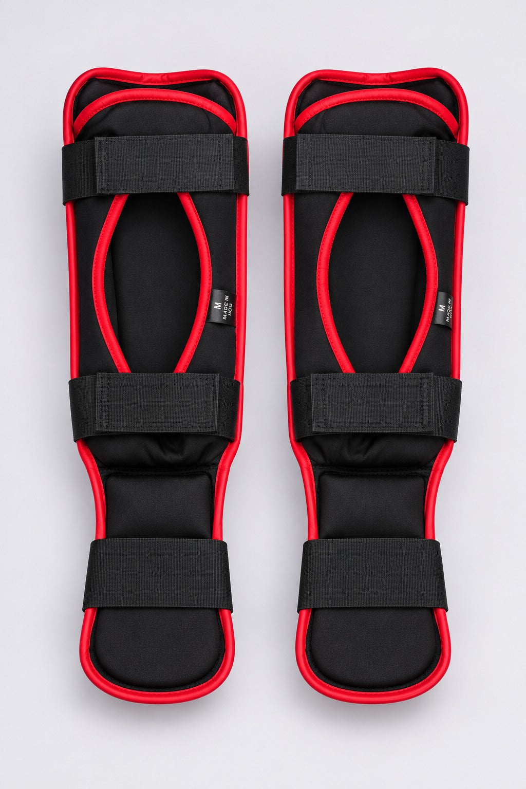 Back of TITLE red shin guards: black padded lining, two calf straps and an under-foot hook-and-loop strap