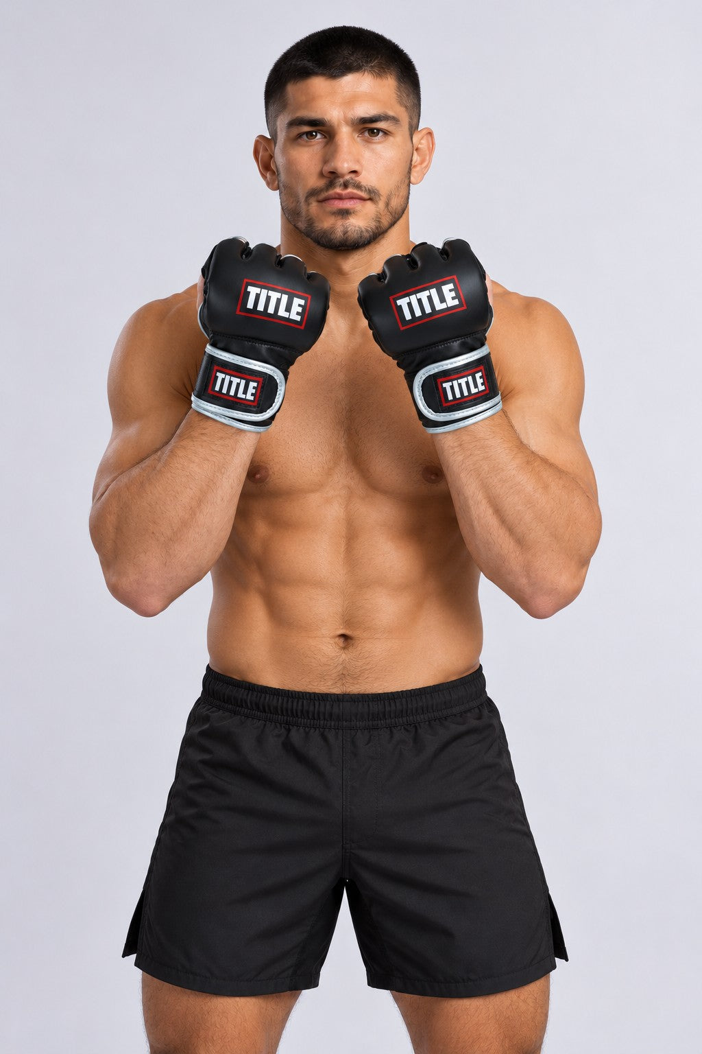 Fighter in a front guard wearing TITLE Powerhide MMA grappling gloves in black with silver piping and logo wrist straps