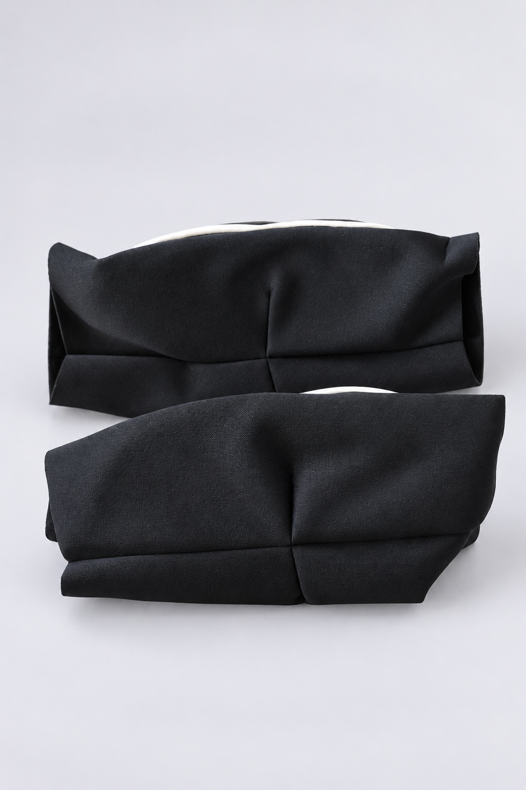 TITLE elbow guards lying flat from behind, showing the elastic sleeve and white pad edge at the side