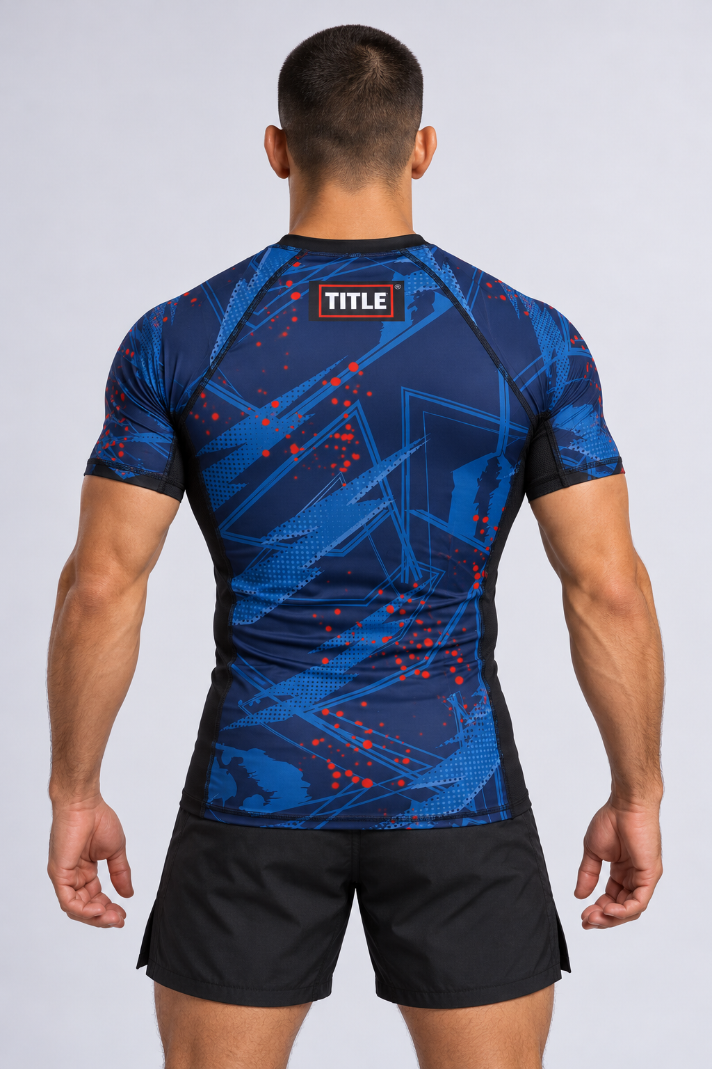 TITLE Chaos navy MMA rash guard from the back, showing the blue and red strike-line print and black cuffs