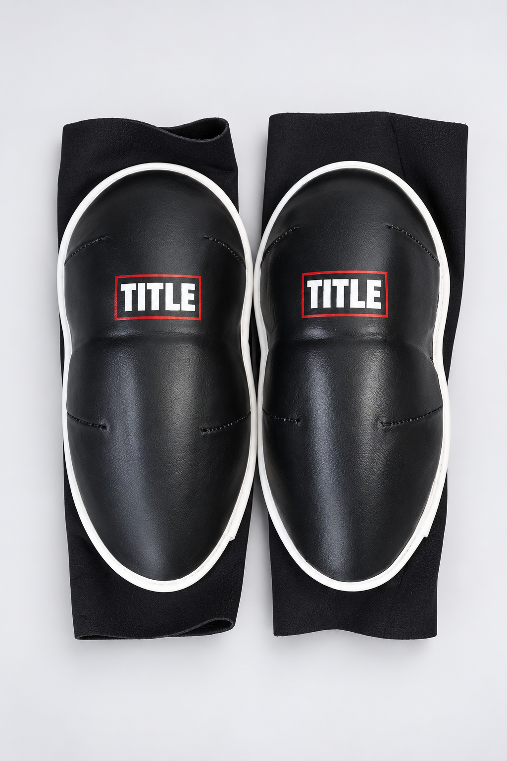 TITLE Clinch knee guards, black slip-on sleeves with moulded leather pads, white piping and red TITLE patch