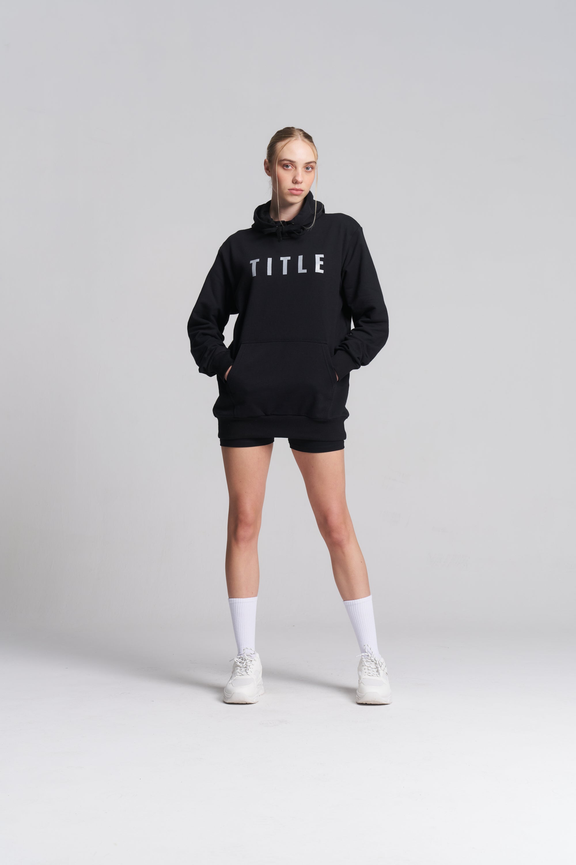 A model wearing a black TITLE Boxing South Africa heavyweight cotton hoodie with a grey chest logo and kangaroo pocket.