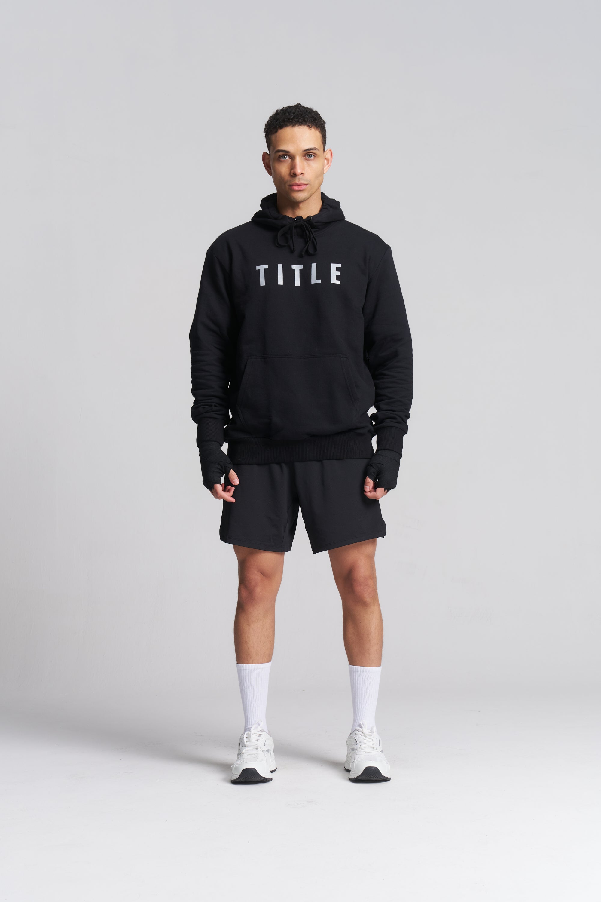 TITLE Boxing South Africa black cotton hoodie with grey chest logo worn by a male athlete with black shorts