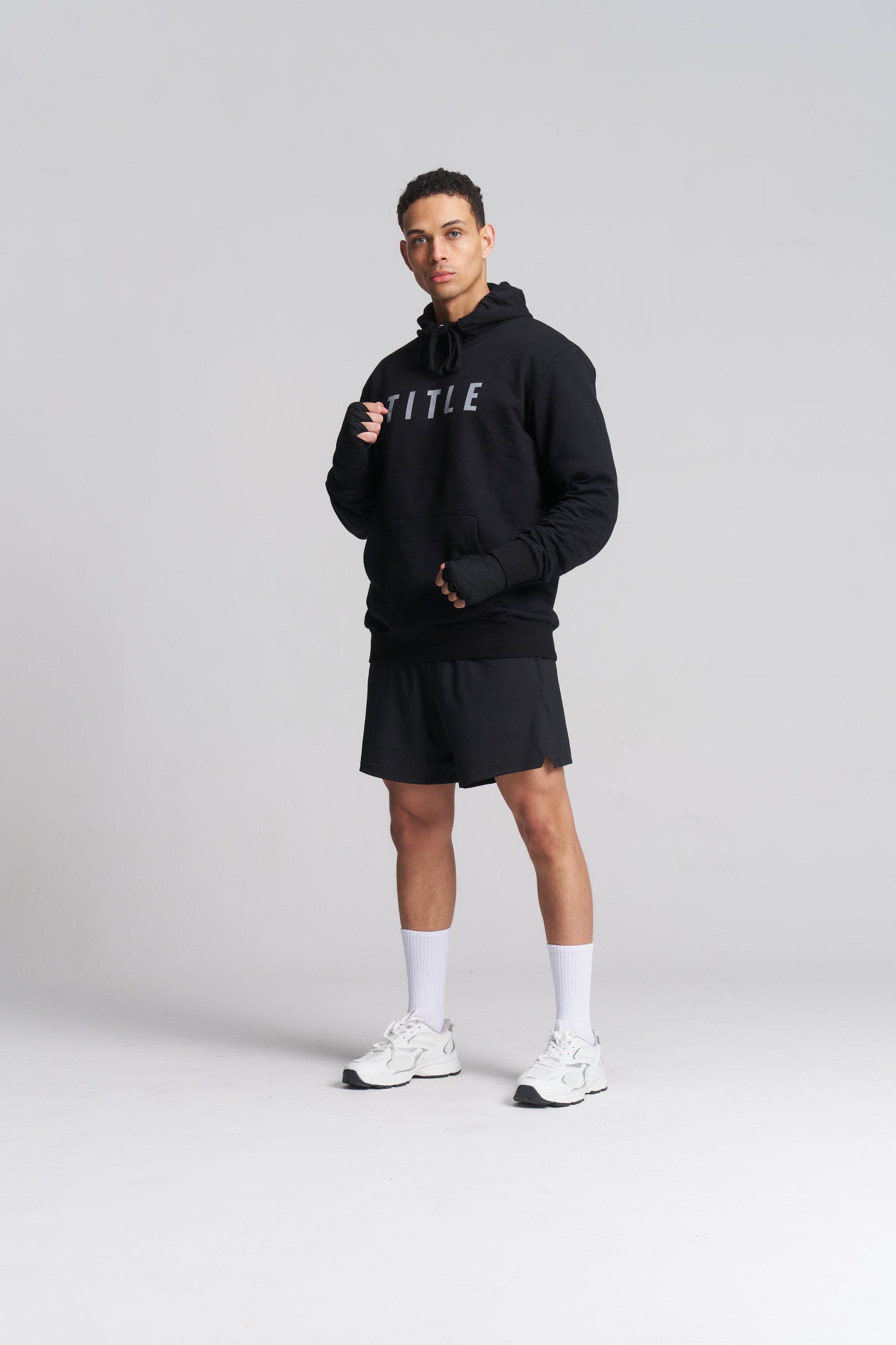 Male athlete wearing a black TITLE Boxing South Africa heavyweight cotton hoodie with grey chest branding