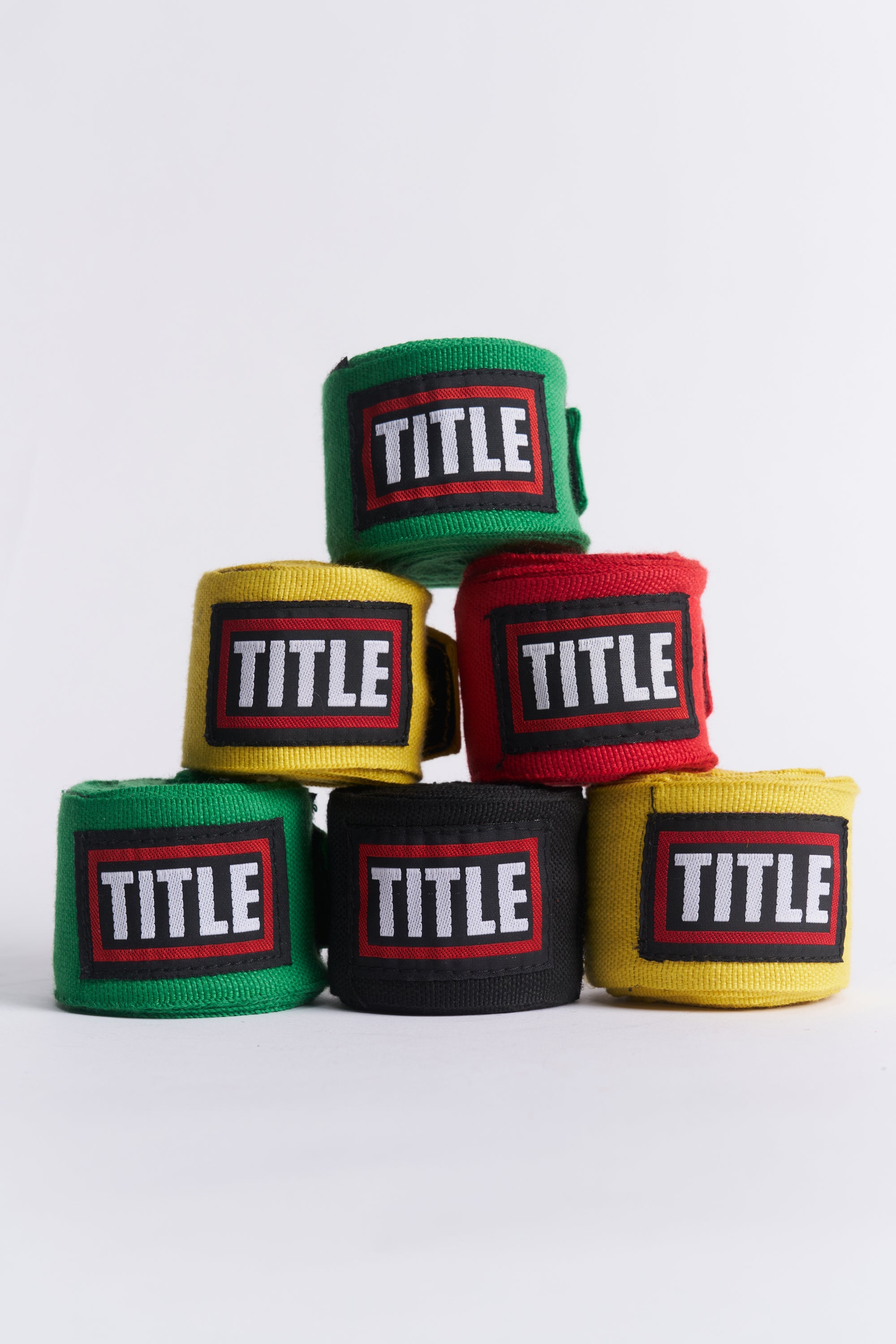 TITLE Boxing South Africa cotton hand wraps in green, yellow, red, and black stacked in a pyramid on a white background
