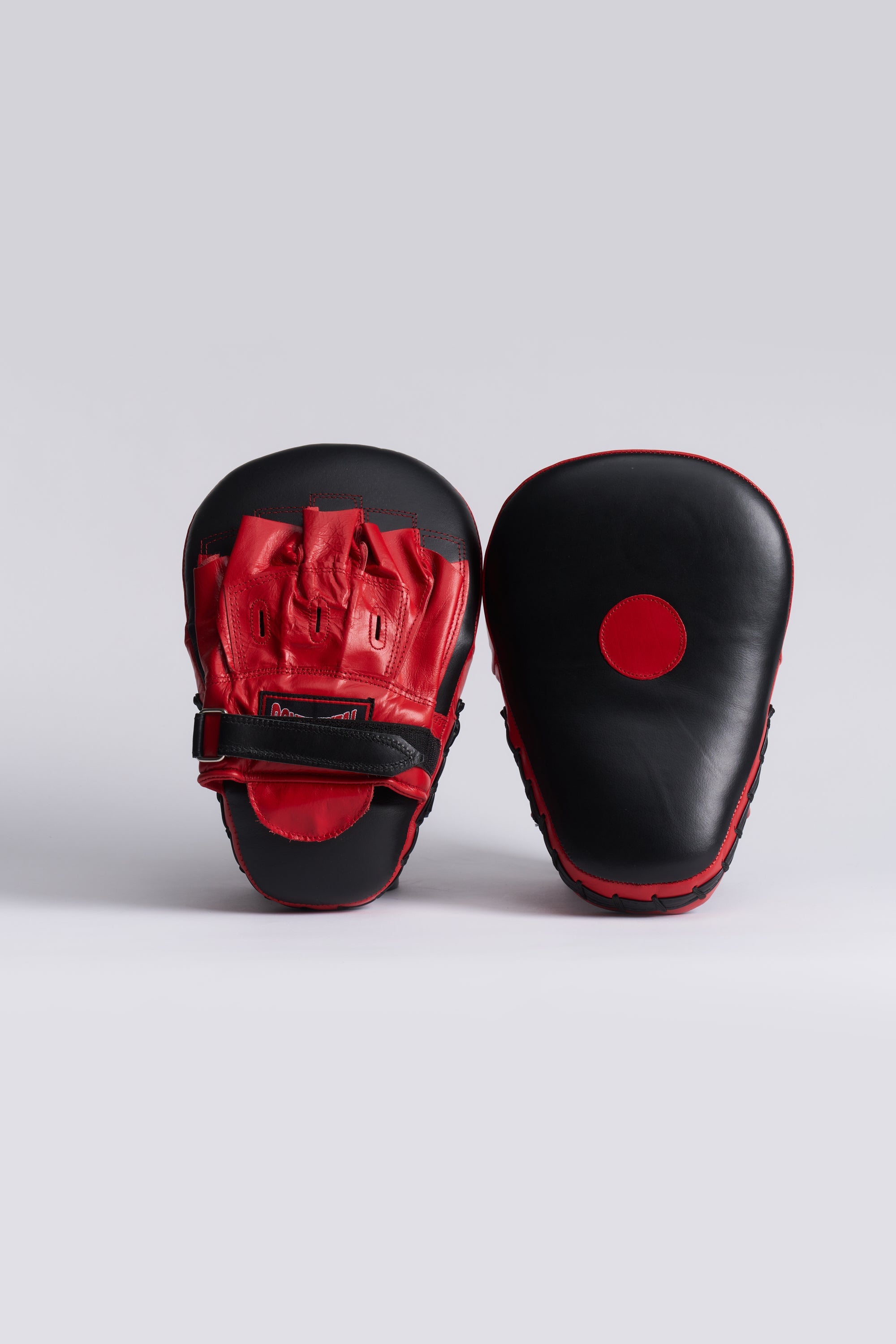 TITLE Boxing South Africa curved leather hook and jab pads in black and red with adjustable hook-and-loop closure.
