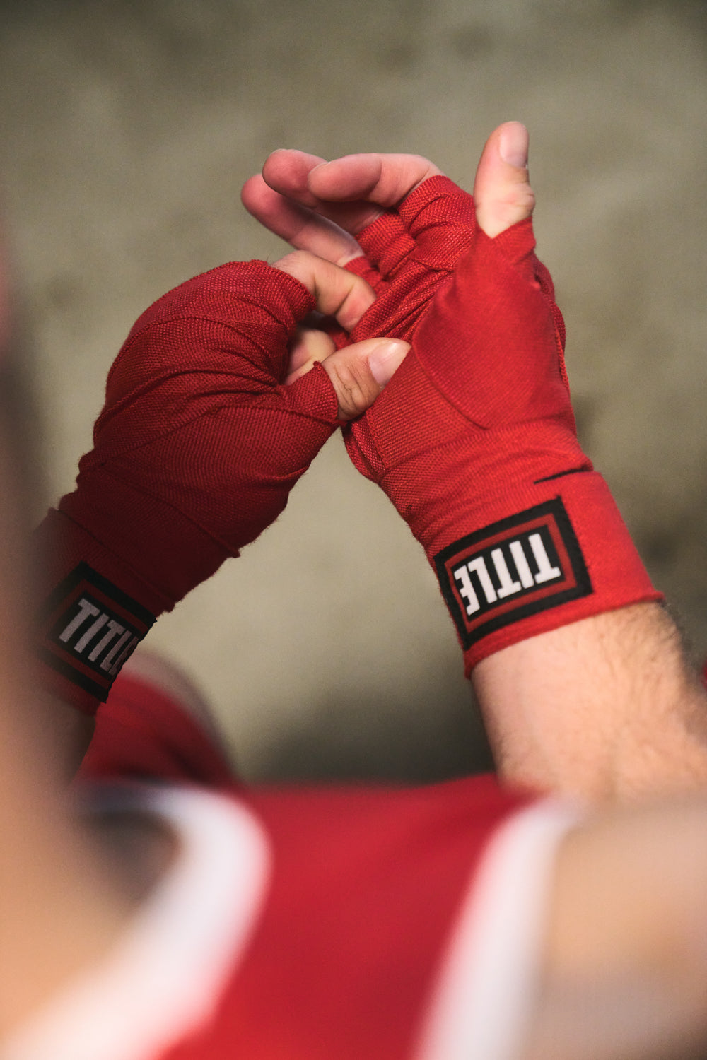 TITLE Boxing South Africa red woven cotton hand wraps being secured around a fighter's hands for wrist support.