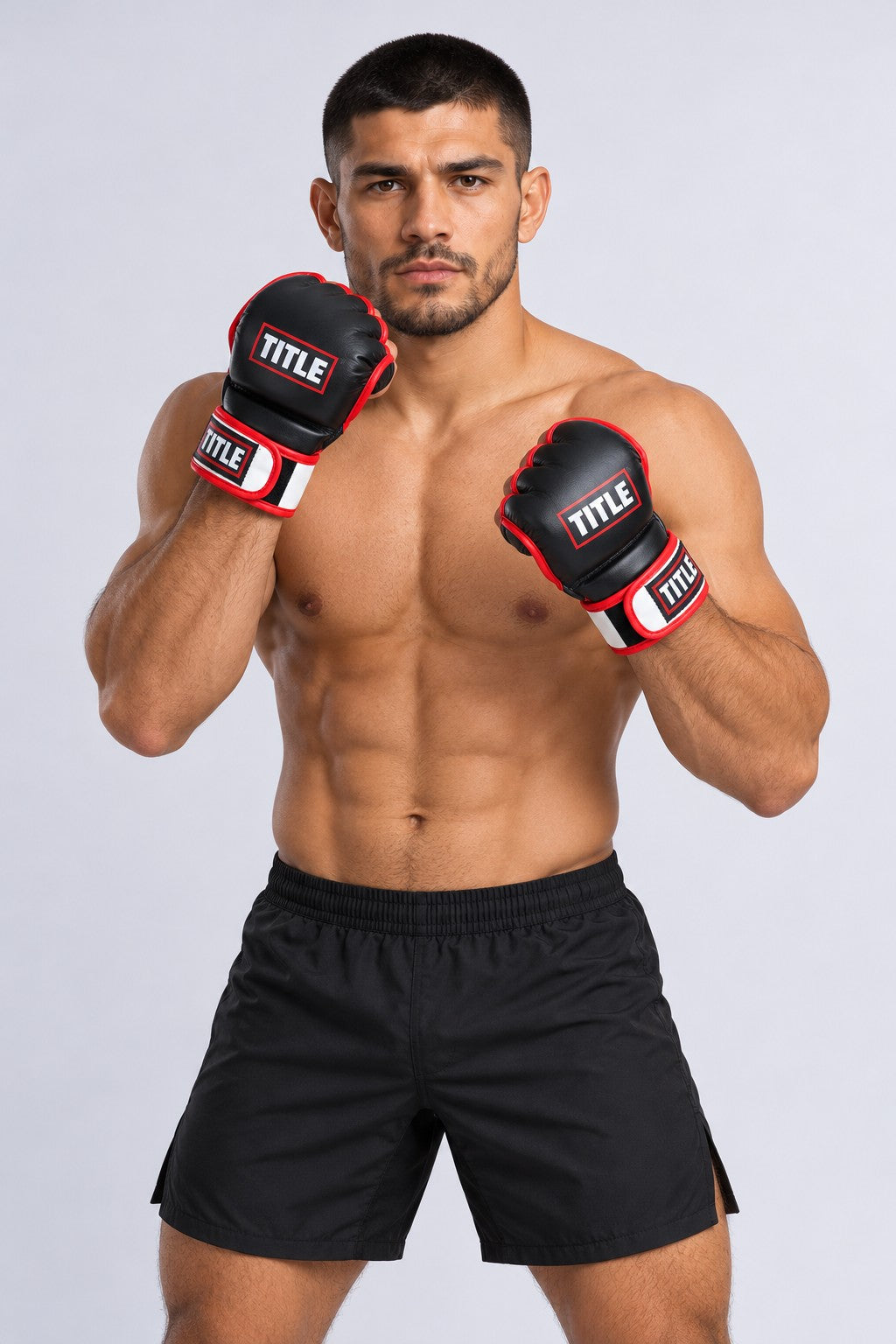 Fighter in a guard stance wearing TITLE MMA grappling gloves in black leather with red trim and a white wrist strap