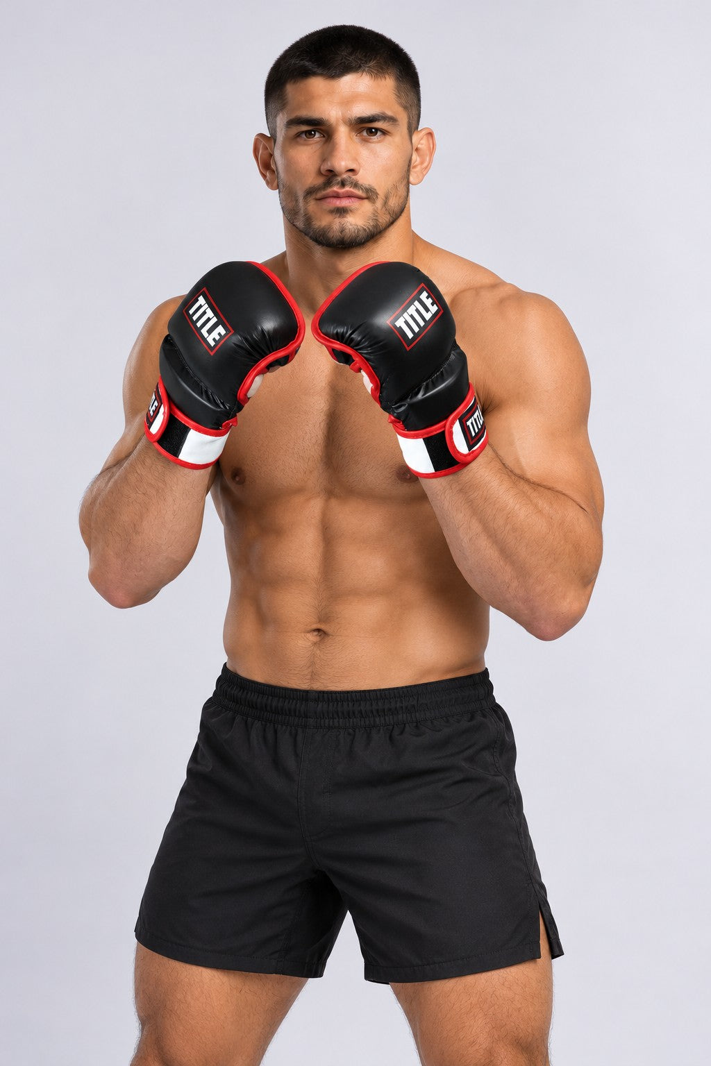Fighter in an angled guard wearing TITLE black leather MMA sparring gloves with padded fingers and red-trimmed wrist straps