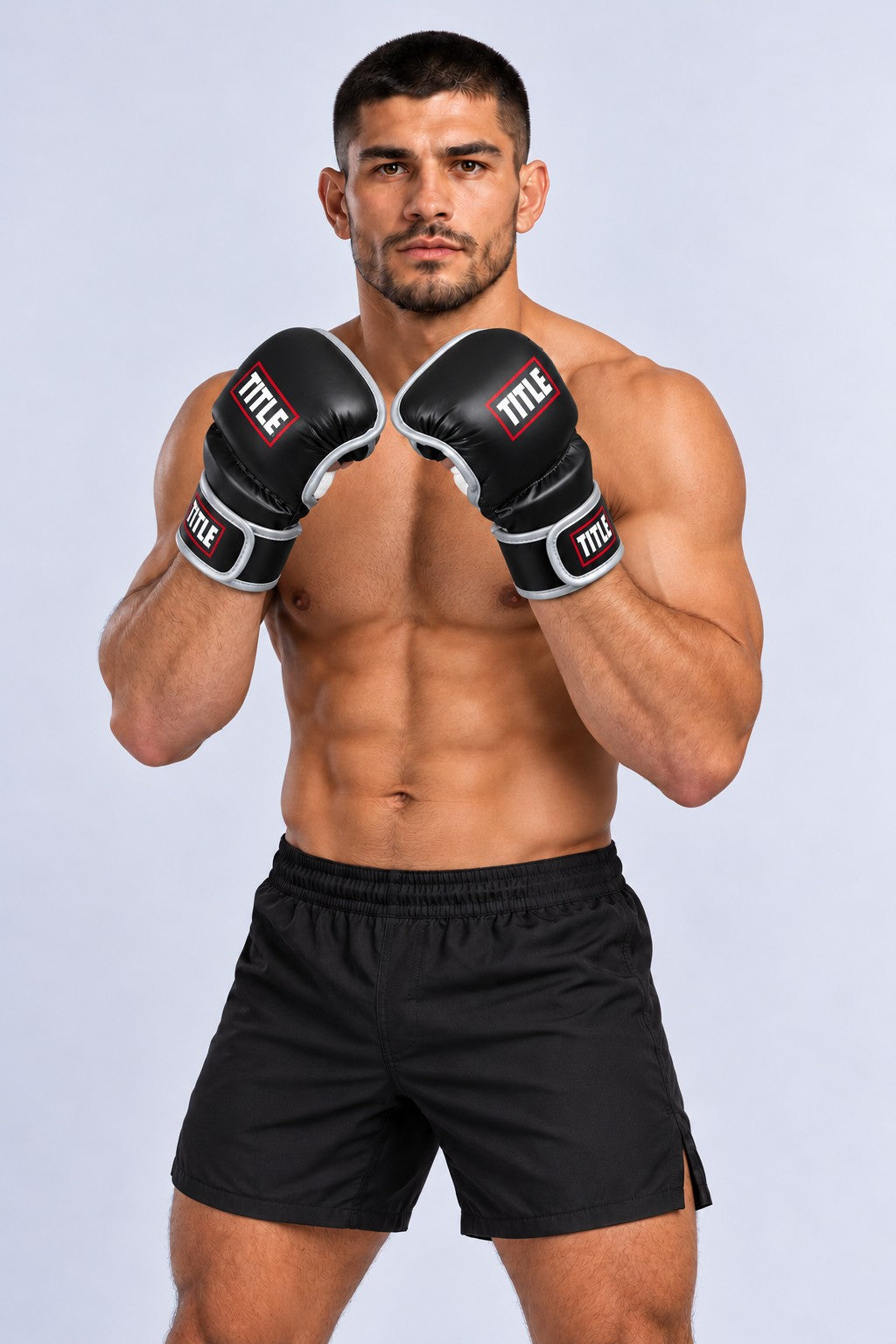 Fighter in an angled guard wearing TITLE black and silver Powerhide MMA sparring gloves with padded knuckles and fingers
